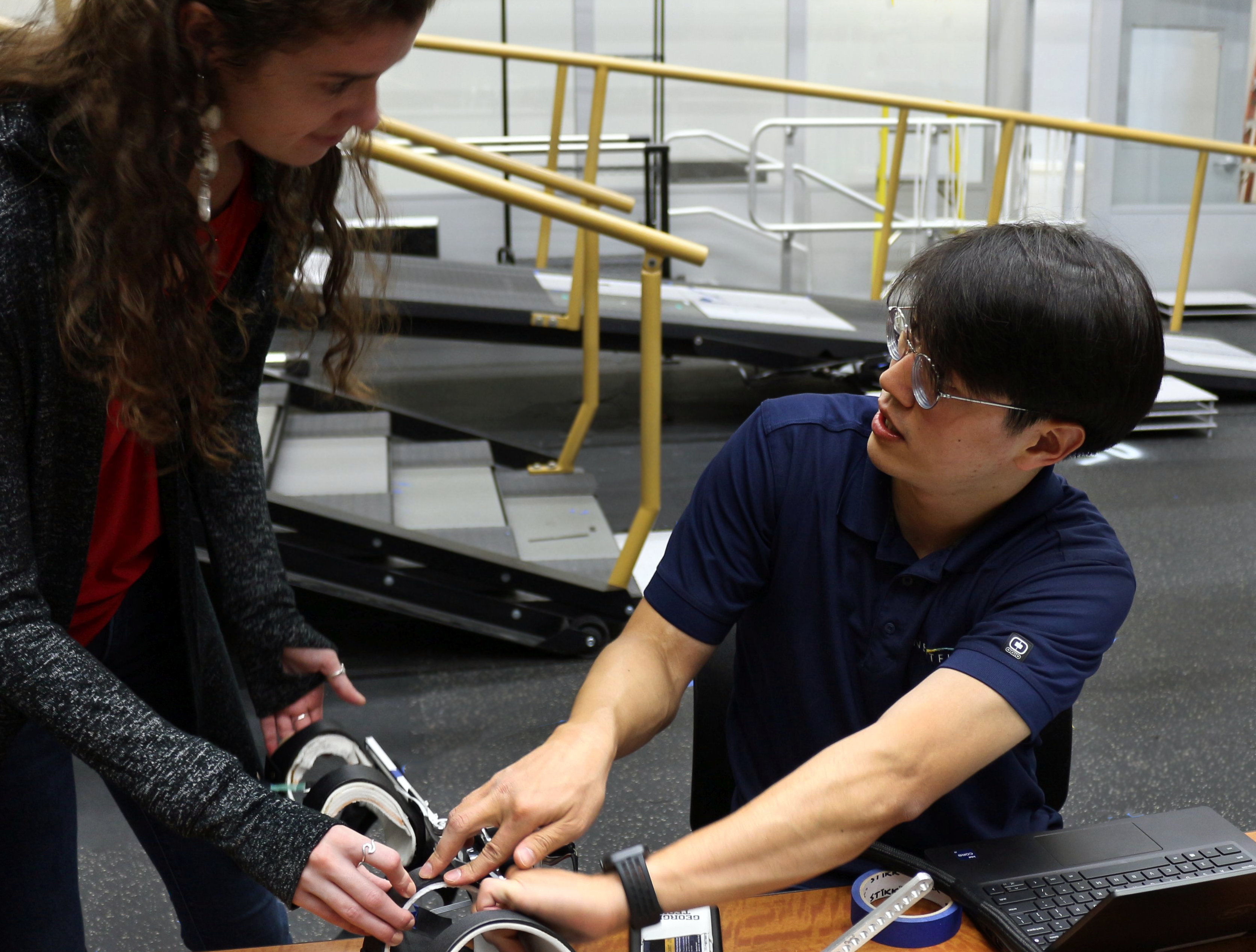 Two people discussing an assistive device